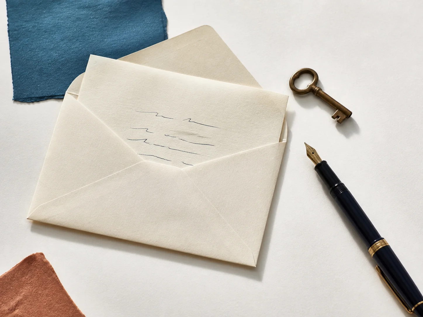Cream envelope, personal letter, fountain pen, and small brass key